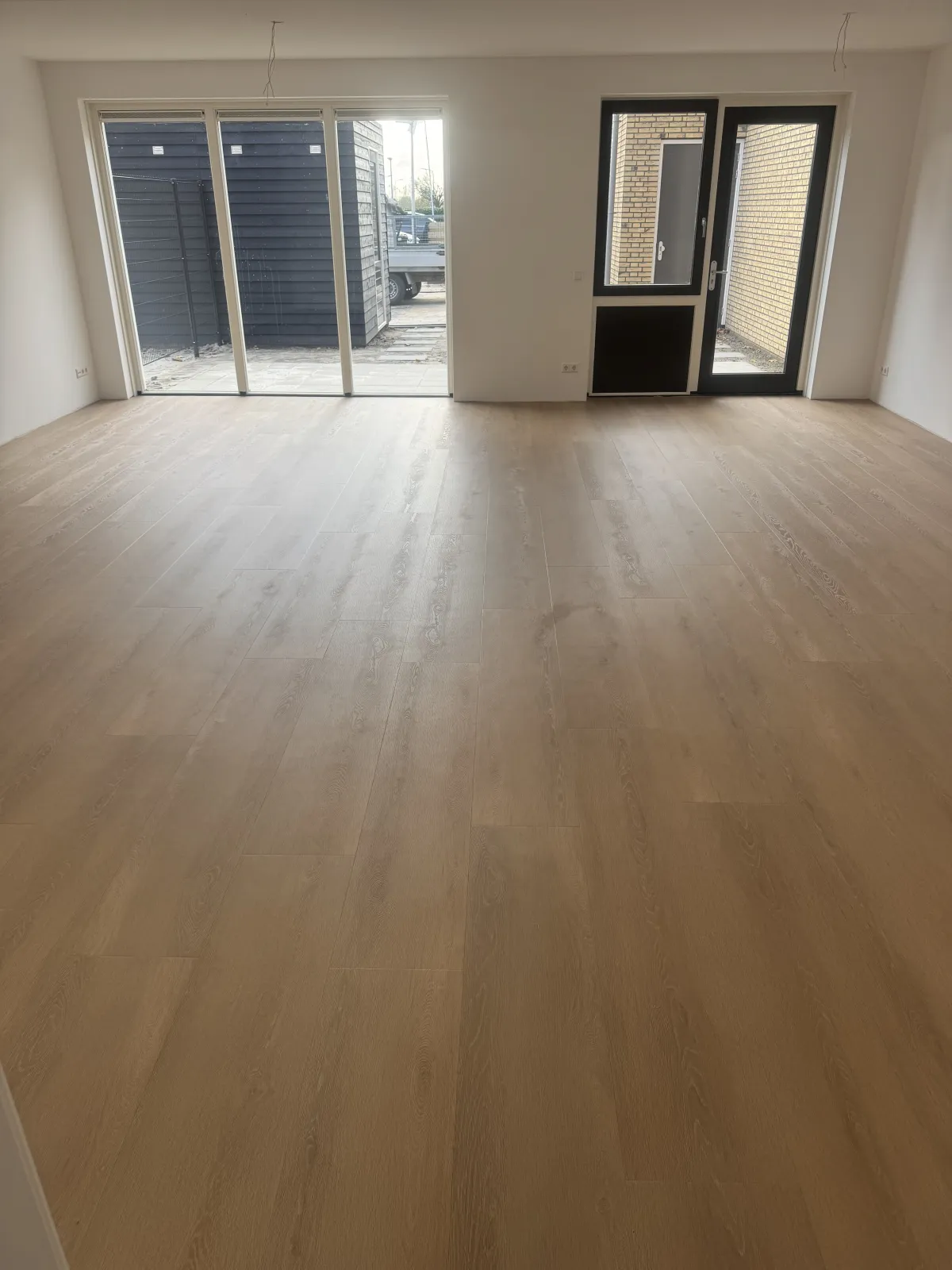 Grijze plankenvloer met veel lichtinval